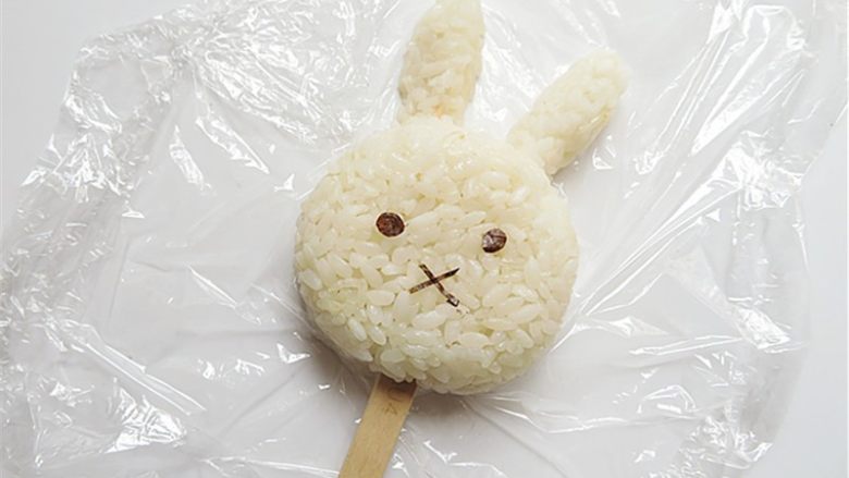 兔子趣味便当,将揉好型的米饭拼成一个兔子头部，贴上眼睛、嘴巴
