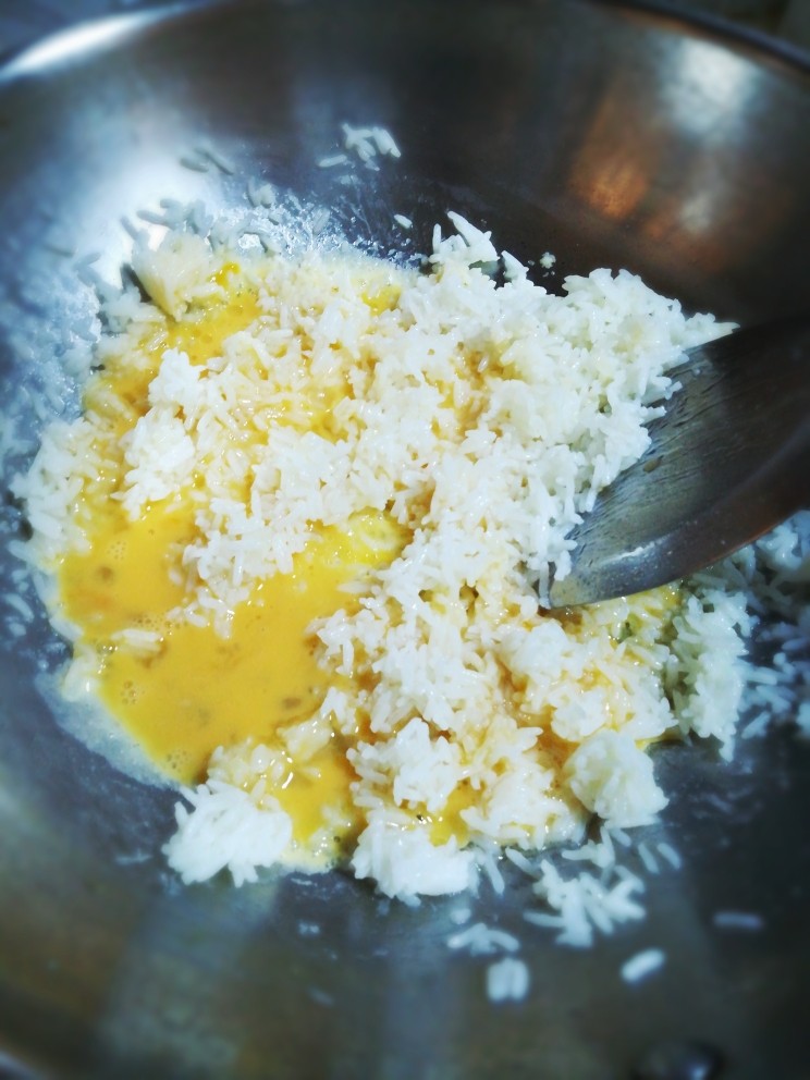 爱心蛋炒饭,加入蛋液，继续拌炒，炒至每粒米饭都裹上蛋液。