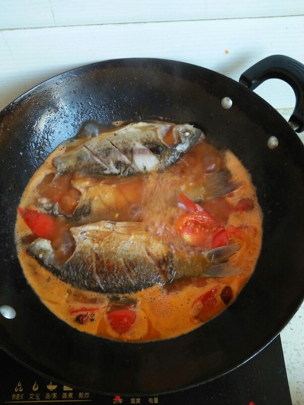 西红柿炖鲫鱼,水煮开以后放入鲫鱼到里面炖。