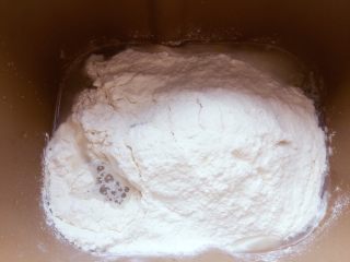 天然酵母葡萄干吐司,把天然酵母、面粉、奶粉、盐、糖、鸡蛋、水倒进面包机