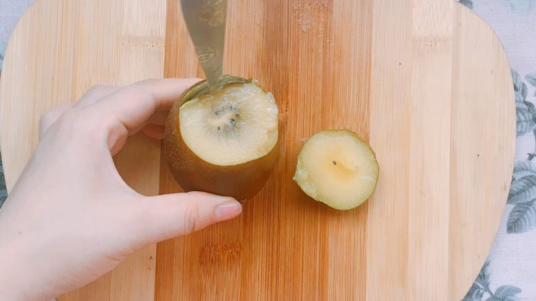 夏日快手香蕉燕麦水果船（减脂餐）,用一个铁勺沿着皮插入，转一圈后就会得到完整的一颗猕猴桃啦，再切成小块备用。