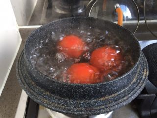 番茄茄丁肉酱拌面,番茄洗干净放入锅中，加水没过番茄。大火煮开。煮到番茄表皮裂开即可。
