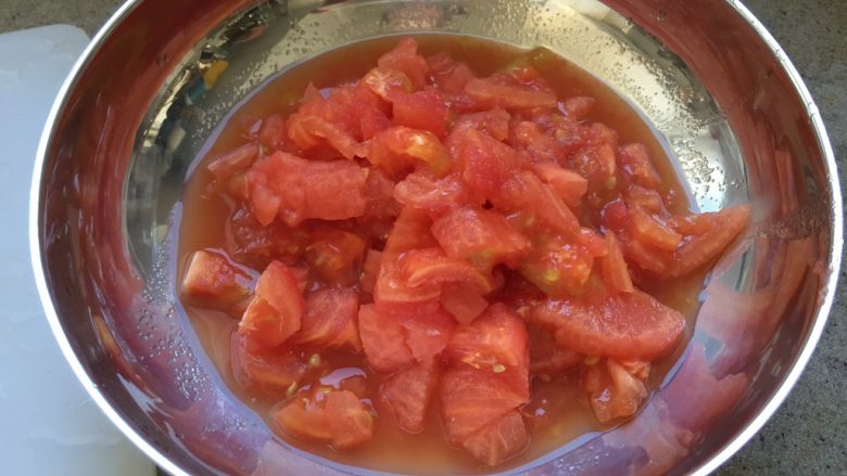 番茄茄丁肉酱拌面,番茄切掉根部，然后切番茄丁。切好的番茄和汁水，一起放入碗里，备用。