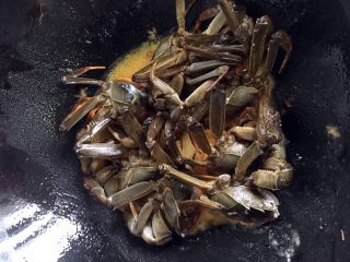 六月黄炒年糕,中火加热后的油锅，此时把螃蟹切面整齐码入锅内，煎两分钟。