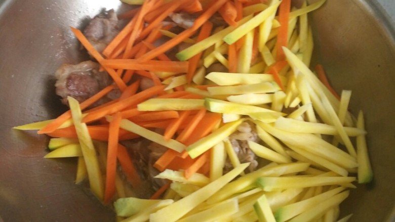 新疆羊排抓饭,倒入黄萝卜和胡萝卜翻炒，放入盐。