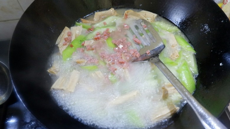一鸡两吃之一汤一菜,滚开以后把火腿丁扔进去，放盐调味儿，出锅。丝瓜嫩，易熟。
