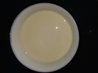 芋圆烧仙草,接下来调制甜奶，炼乳取出一大勺倒入纯牛奶中，搅拌均匀。