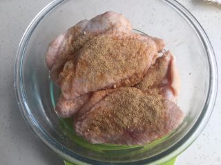 电饭煲鸡翅,把1克姜粉倒入鸡翅碗，均匀抹开。