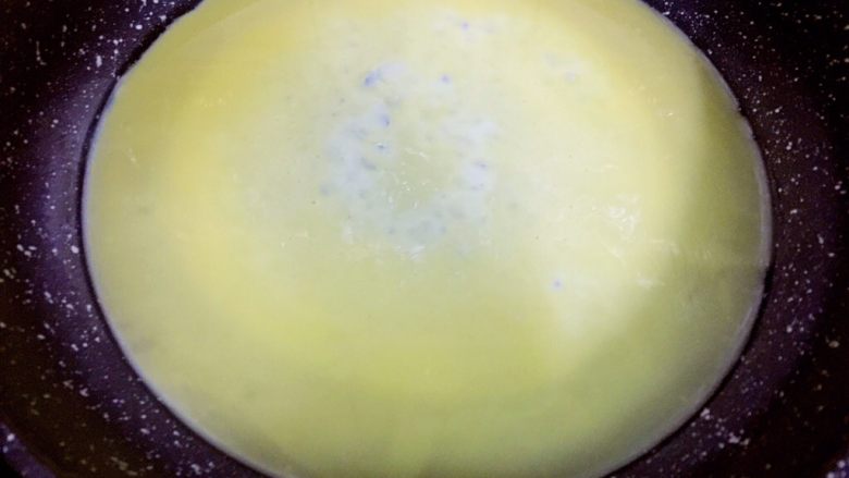培根胡萝卜鸡蛋卷饭团,保持小火，将蛋液倒入锅内，晃动锅
使蛋液铺满锅底