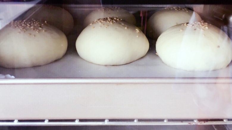 松软汉堡胚,把面包送入预热好的烤箱，中层，上下火180度烘烤18min，上色后及时加盖锡纸。