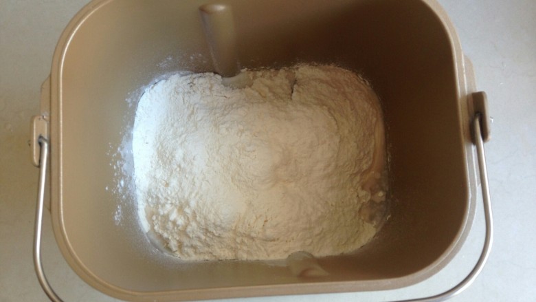 莲藕排包,加入面粉和切成小块的黄油，在面粉顶端加入酵母，面包桶放入到面包机内，选择和面程序，十分钟。