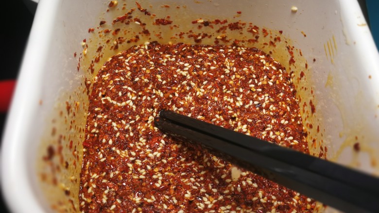 厨房神器之___飘香红油,过一会儿再浇第三勺如此反复，停顿的时间差可以防止油温过高辣椒被炸焦变色。