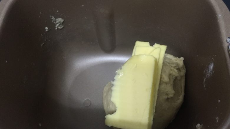 卡路里炸弹 咕咕霍夫重油面包,25分钟后，将软化的黄油分3次加入到面团中，因为这个面包的黄油含量高，不是很容易吸收，所以一定要分次加入，融合后再加下一次黄油