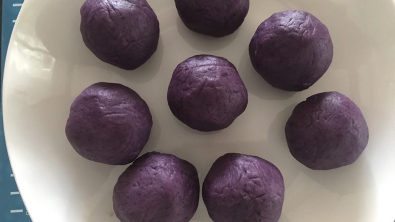 抹茶紫薯蛋黄酥,包好的紫薯蛋黄球用保鲜膜包好