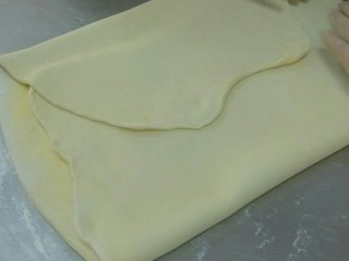 红豆丹麦包,将面团两边对折包住奶油，趁面团还没完解冻