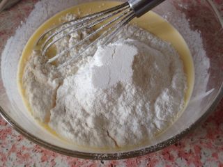 酸奶拉花蛋糕,玉米淀粉和低筋面粉过筛加到蛋黄糊中，以翻拌的方式搅拌到无颗粒顺滑状备用