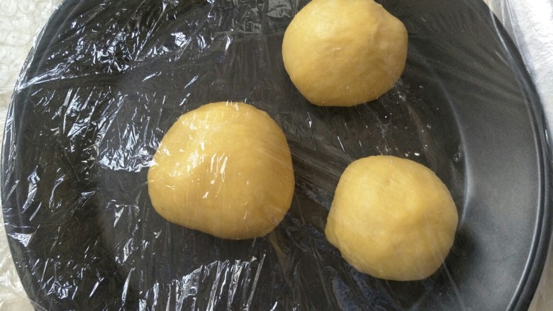 毛毛虫面包,发酵好的面团取出来，揉一揉排气，分成三等分。盖上保鲜膜静置15分钟。