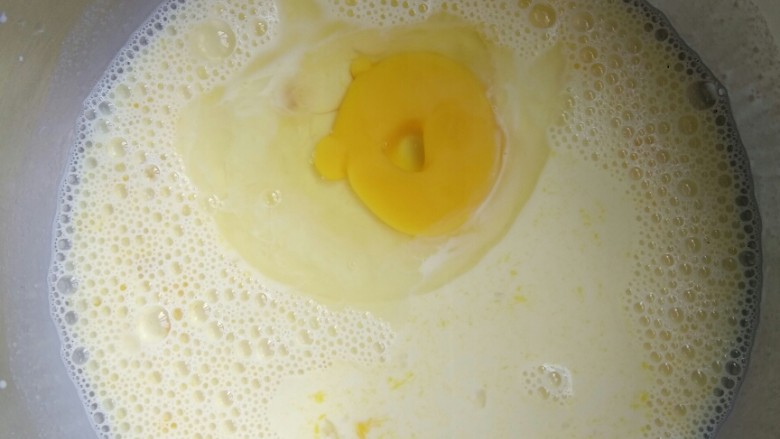 无奶油版蛋挞,先把两个蛋黄分次放入纯牛奶中，用打蛋器搅拌均匀，然后再打入一个整个鸡蛋搅拌均匀