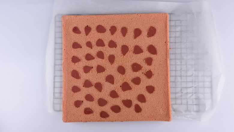 草莓花式蛋糕卷,揭开底部的硅胶垫散热，同时底部也盖张油纸防止水分流失