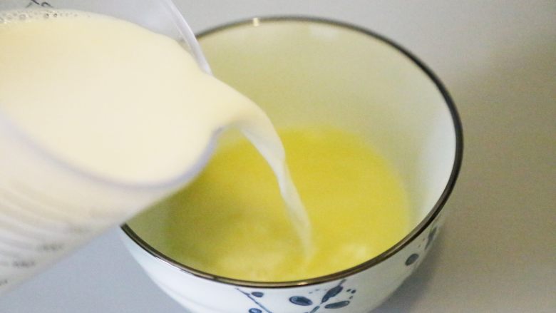 自制姜撞奶,冲入刚刚的热牛奶。
牛奶离碗口约15厘米，让“撞”的过程中，姜汁和牛奶充分融合。