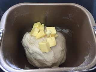 炼奶提子吐司,揉面好之后加入软化室温的黄油，继续揉面20分钟