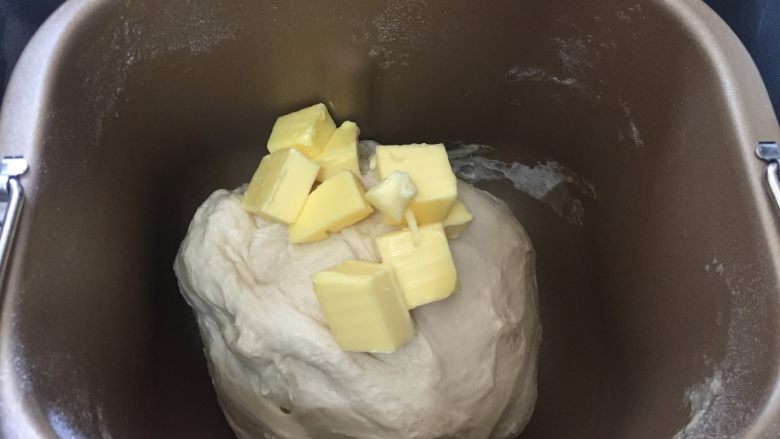 炼奶提子吐司,揉面好之后加入软化室温的黄油，继续揉面20分钟