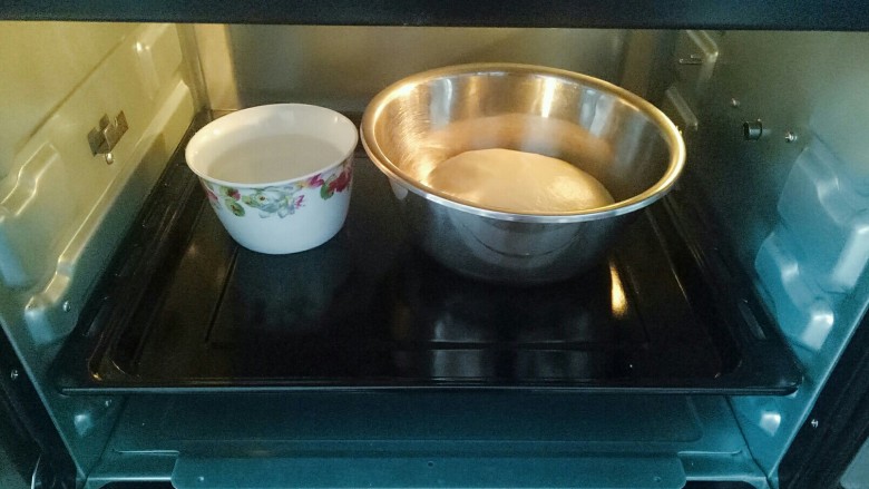 辫子面包,将面团整形放入容器中，在放一碗热水（防止面包表皮干），放入烤箱进行第一次发酵1个小时