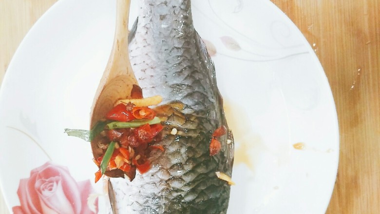 蒸鲫鱼,将调料均匀的放在鱼的身上。