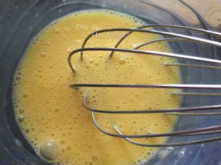 火腿蒜香雞蛋卷,將雞蛋打入大碗里，用手動打蛋器打散均勻