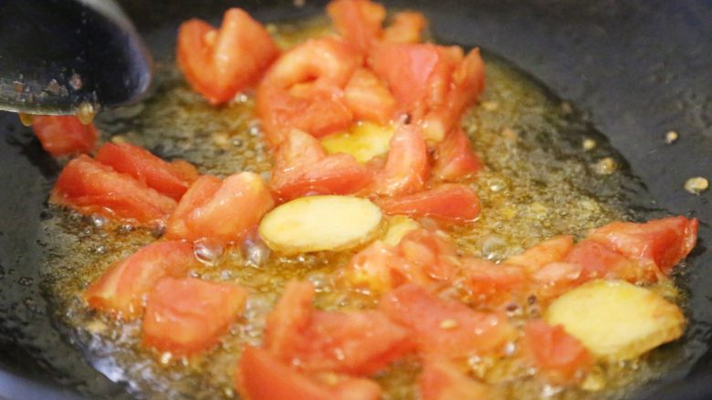 巴沙酸汤鱼,放入姜片、切块的西红柿，煸炒至出香味，西红柿出沙。