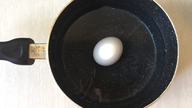 油菜鳕鱼蛋黄粥,鸡蛋先放奶锅里加水煮。