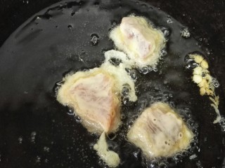 菠萝咕咾肉,把裹满蛋糊的肉放进油里炸