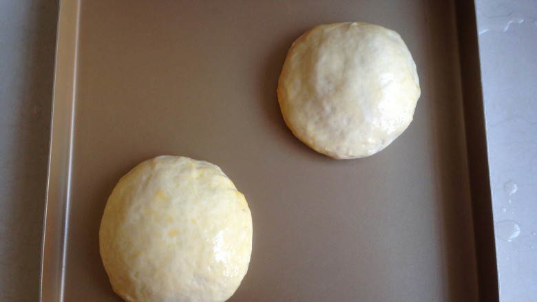 脆皮肠面包袋,发酵好的面包取出，面包胚上涂上蛋液。