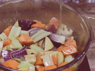 三汁焖锅,倒入切好的蔬菜翻炒，撒盐和胡椒翻炒均匀；倒入适量清水，大概在蔬菜一半的位置