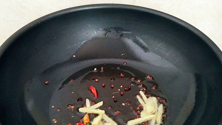 香辣蚕蛹,锅中放油烧热，放入花椒粒，姜，辣椒呛出香味。