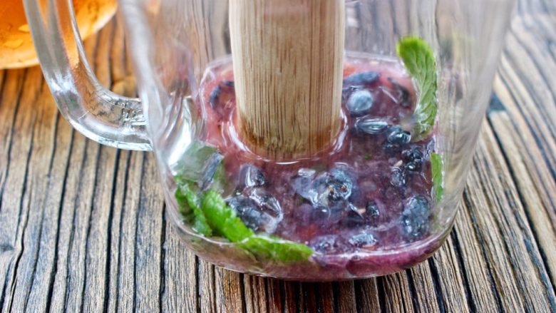 蓝莓Mojito鸡尾酒,用小棍压破蓝莓，挤压出水份