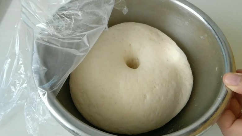 礼帽小企鹅面食,面团发酵到这样，用手摁下去，坑不回缩，发酵好了。