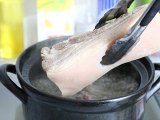 传统秘制 梅干菜扣肉,将肉捞起来，冲去表面的浮沫。