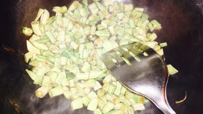 葱油豆角焖饭,放入切好的豆角翻炒两分钟，放少许盐！