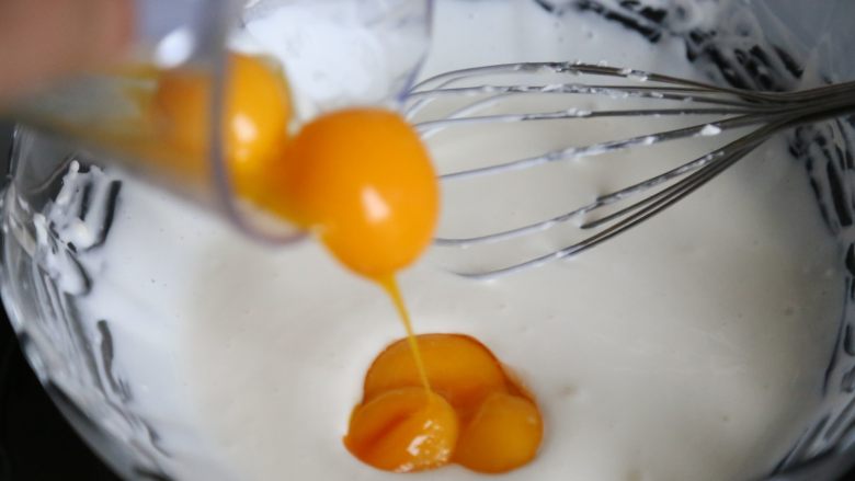 轻乳酪蛋糕,把装奶油奶酪的碰从热水里拿出来，加入分好的蛋黄。