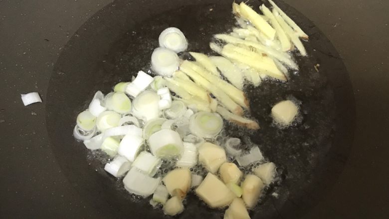 超下饭的油爆花蛤,锅内加少许油，依次放入姜丝、蒜块、大葱圈，爆香