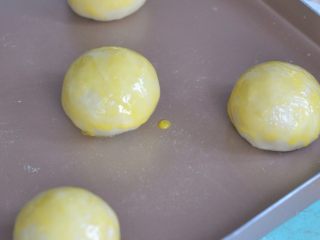 香芋蛋黄酥,放入烤盘中，表面刷一层蛋黄。放入烤箱，170度烘烤10分钟。