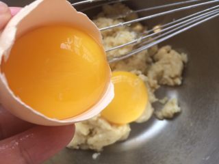 玉枕蛋糕,这时的面糊比较干，把鸡蛋的蛋白蛋黄分开，蛋白放入干净的打蛋盆里，蛋黄放入面糊中轻轻搅拌混合均匀。