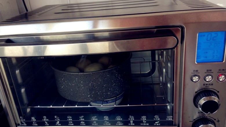 花辫豆沙面包,将模具放入到烤箱内，下面放着一碗热水，选择烤箱的发酵功能40分钟。