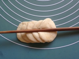花辫豆沙面包,10克的面团擀圆，五片叠放在一起，用筷子在中间压一下，从最后一片向内卷起来，然后在中间切一刀，做成两朵玫瑰花。
