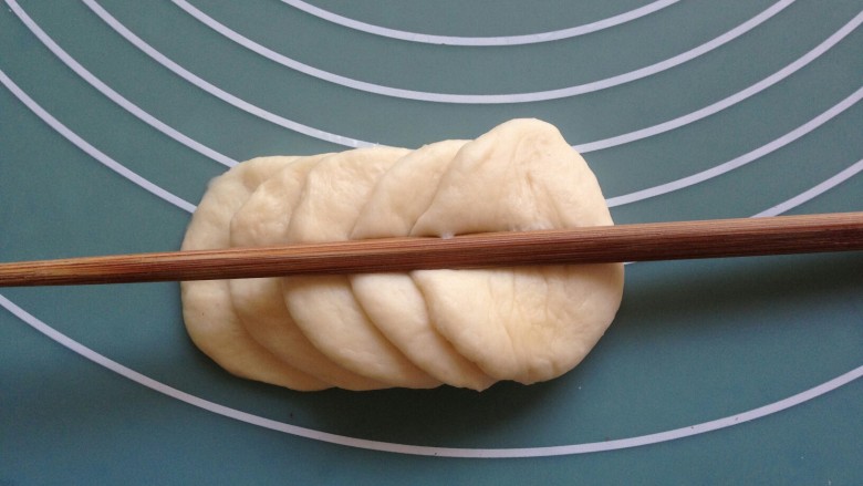 花辫豆沙面包,10克的面团擀圆，五片叠放在一起，用筷子在中间压一下，从最后一片向内卷起来，然后在中间切一刀，做成两朵玫瑰花。