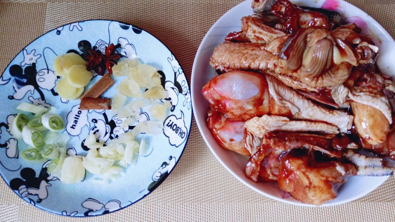 家常红烧鸡块,葱姜蒜去皮，切碎，腌制好的鸡块取处出倒在盘子里。