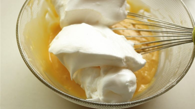 fluff香草棉花糖杯子蛋糕,挖一些蛋白霜到蛋黄糊里。