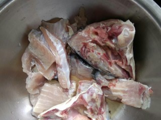懒人版砂锅酸菜鱼,把剔出来的鱼骨剁成块，鱼头从中间劈开。用适量料酒，适量胡椒粉，一点盐腌一会儿