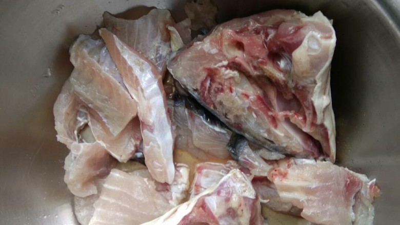 懒人版砂锅酸菜鱼,把剔出来的鱼骨剁成块，鱼头从中间劈开。用适量料酒，适量胡椒粉，一点盐腌一会儿
